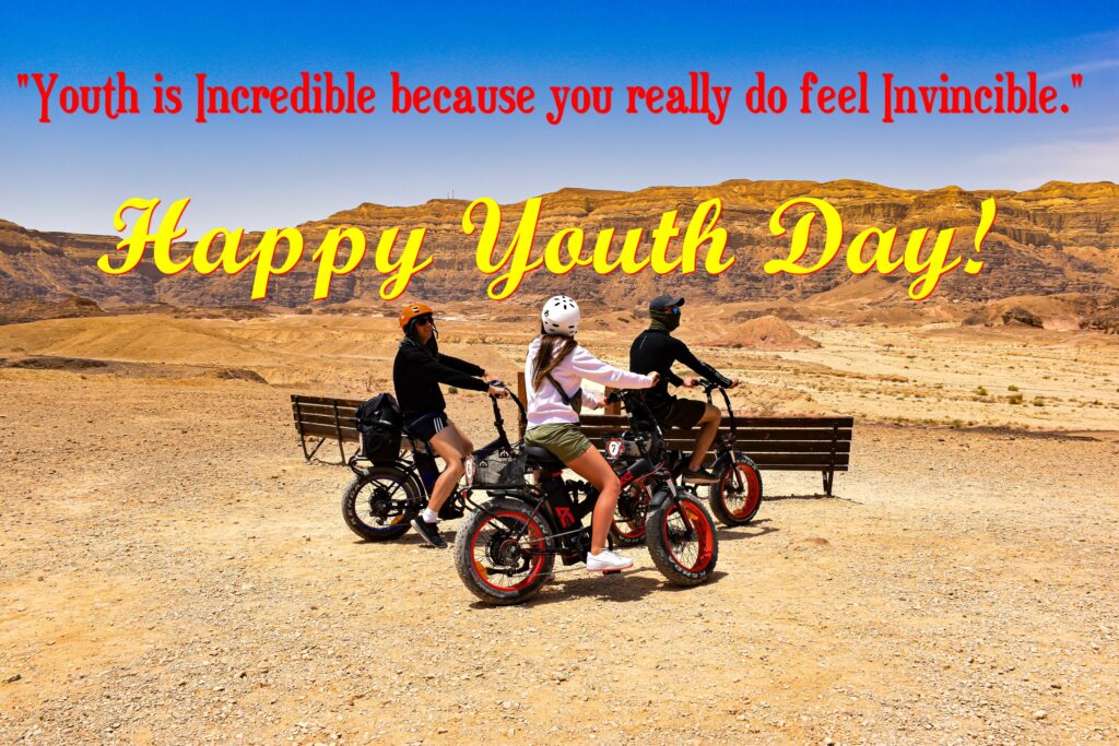 Three youths riding bikes in desert mountain, International youth day.